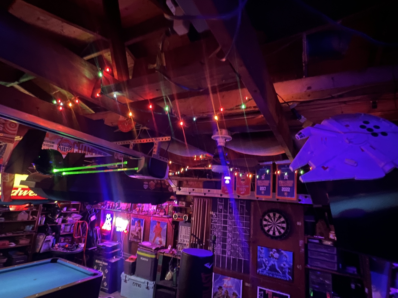A neon-lit garage game room filled with Houston memorabilia and science-fiction models